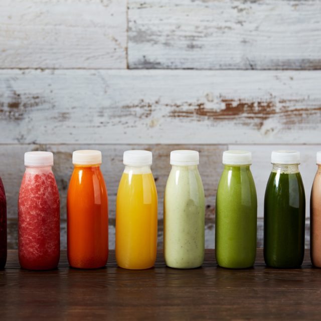 A row of different coloured bottles of juices and smoothies