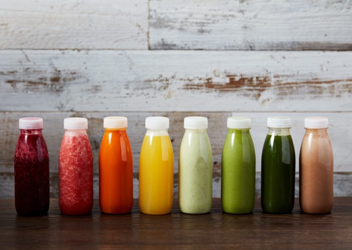 A row of different coloured bottles of juices and smoothies